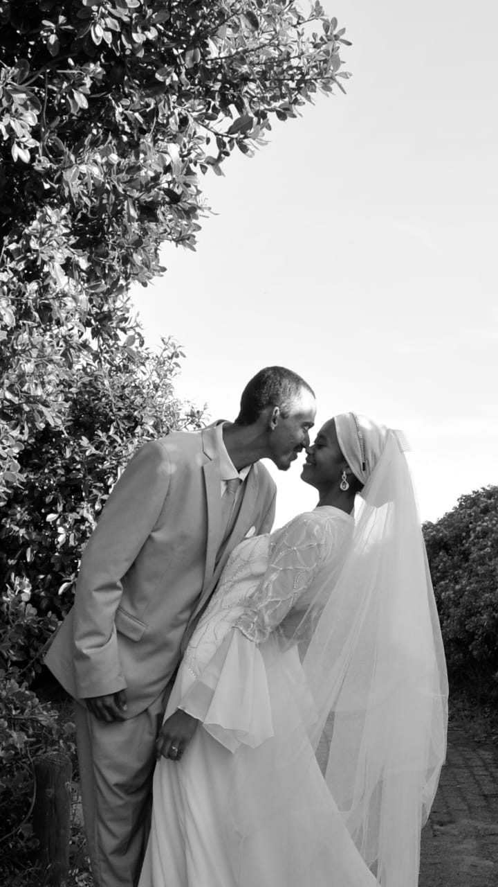 Black and white portrait of bride and groom forehead to forehead