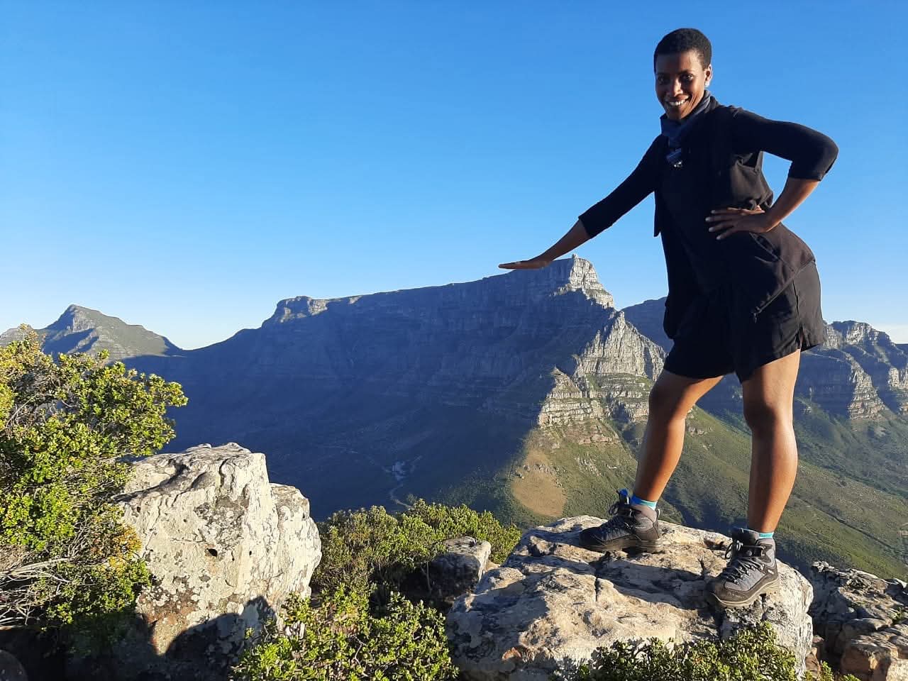 Tasneem on top of Lion's Head with Table Mountain in the background